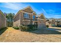 Side view of a two-story brick home showcasing the driveway and landscaping at 2045 Broadmoor Way, Fairburn, GA 30213