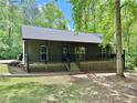 Charming single-story home with a covered front porch and a well-maintained lawn surrounded by lush trees at 93 Mill Creek Rd, Hiram, GA 30141