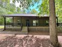 Inviting single-story house with a spacious covered porch and lattice accents, nestled among mature trees at 93 Mill Creek Rd, Hiram, GA 30141