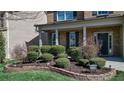 Landscaped front yard with neatly trimmed hedges and a stone retaining wall with the house number 209 at 209 Providence Walk Ct, Canton, GA 30114