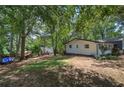 Spacious backyard featuring a large grassy area, mature trees, and an outbuilding on the rear of the property at 1240 Evans Cook Rd, Canton, GA 30115