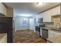 Modern kitchen with stainless steel appliances, granite counters, white cabinets, and hardwood flooring at 2303 Pinewood Dr, Decatur, GA 30032