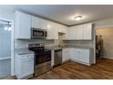 Bright kitchen with white cabinets, stainless steel appliances, granite countertops, and hardwood floors at 2303 Pinewood Dr, Decatur, GA 30032