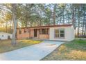 Single-story home with brick and siding, long driveway, and mature trees on a sunny day at 546 W Sherwood Dr, Riverdale, GA 30274