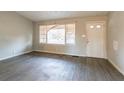 Living room with hard surface flooring, a large window with a damaged blind, and a front door at 546 W Sherwood Dr, Riverdale, GA 30274