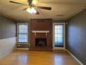 Cozy living room with a brick fireplace, hardwood floors, and plenty of natural light from two windows at 634 S Jeff Davis S Dr, Fayetteville, GA 30215