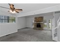 Spacious living room with a stone fireplace, ceiling fan, and bright windows at 1458 Walnut Log Pl, Austell, GA 30168