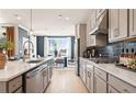 Gorgeous kitchen with stainless appliances, sleek counters and modern backsplash, flowing into an eat-in dining space at 3119 Shirecrest Ln, Dacula, GA 30019