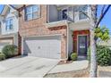 Close up view of a brick and siding townhome with an attached two-car garage and front door at 1062 Haley Woods Ct, Lawrenceville, GA 30043