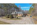 Spacious single-story home with a circular driveway and surrounded by mature trees at 210 Cowan Se Rd, Conyers, GA 30094