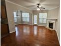 Open living room with hardwood floors, fireplace, and abundant natural light from multiple windows at 115 Sunset Ln, Woodstock, GA 30189