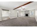 Spacious living room featuring a stone fireplace, plush carpeting, and a ceiling fan for added comfort at 1876 Winding Creek Sw Ln, Marietta, GA 30064