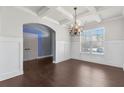 Bright dining area with wainscoting, coffered ceiling, dark floors, and a large window offering natural light at 3313 Alhambra Cir, Hampton, GA 30228