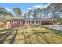 Well-maintained red brick home with mature trees and a lush green lawn at 4218 Hideaway Dr, Tucker, GA 30084