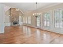 Spacious living room with hardwood floors, stone fireplace, and bright light from the large windows at 6205 Arnall Nw Ct, Acworth, GA 30101