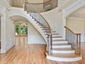 Grand foyer showcasing a curved staircase with wrought iron spindles, hardwood floors and decorative trim at 6205 Arnall Nw Ct, Acworth, GA 30101