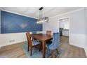 Stylish dining room featuring a blue accent wall, wood flooring, and modern light fixture at 6507 Bennington Dr, Tucker, GA 30084