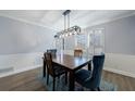 Elegant dining room with wood table, modern light fixture, and shuttered window at 6507 Bennington Dr, Tucker, GA 30084