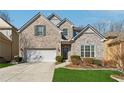 Two story home with a brick and stone facade, attached garage, and newly installed green grass at 5955 Princeton Run Trl, Tucker, GA 30084