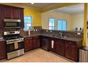 Well-equipped kitchen featuring stainless steel appliances, granite countertops, and wood cabinets at 4312 Defoors Farm Trl, Powder Springs, GA 30127