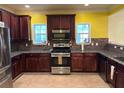 Modern kitchen with stainless steel appliances, granite countertops, and dark wood cabinets at 4312 Defoors Farm Trl, Powder Springs, GA 30127