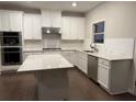 Bright kitchen with white cabinets, stainless appliances, and a central island at 397 Wellspring Way, Sandy Springs, GA 30328