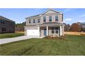 Beautiful new construction with a two-car garage, manicured lawn, freshly poured driveway, and attractive blue door at 108 Dalston Cv, Stockbridge, GA 30281