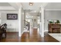 Elegant home foyer with hardwood floors, white columns, wainscoting, and a staircase leading to the upper level at 5650 Copper Creek Pass, Cumming, GA 30040