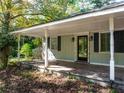 Front porch with black door and matching shutters, supported by white pillars and two outdoor sconces at 724 Se Cowan Se Rd, Conyers, GA 30094