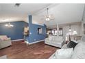 Bright living room features hardwood floors, a ceiling fan, a view to the kitchen, and access to the dining room at 1971 Commonwealth Way, Grayson, GA 30017