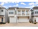 Charming two-story home featuring a dual garage and a quaint second-story balcony, perfect for suburban living at 118 Village Green Ave, Woodstock, GA 30189