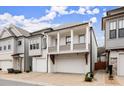Charming two-story home featuring a dual garage and a quaint second-story balcony, perfect for suburban living at 118 Village Green Ave, Woodstock, GA 30189