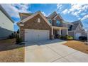 Attractive home featuring a spacious driveway, stone detailing, and a welcoming front porch at 120 Woodford Ln, Canton, GA 30115