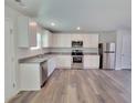 An open-concept kitchen featuring stainless steel appliances, light cabinets, and granite countertops at 15 Heyman Dr, Covington, GA 30016