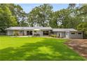 A spacious backyard with a well-kept lawn, patio seating area, and mature trees at 3306 Briarcliff Ne Rd, Atlanta, GA 30345