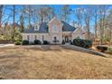 Charming home featuring a stone facade, arched windows, mature trees and a well manicured lawn at 4990 Sawgrass Nw Pl, Acworth, GA 30102