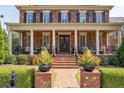 Charming brick home with inviting porch and landscaped front yard featuring brick steps and decorative planters at 8025 Georgetown Cir, Suwanee, GA 30024