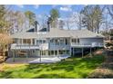 A beautiful back exterior with a patio and a multi-level deck offers views of the manicured lawn at 6475 Holland Dr, Cumming, GA 30041