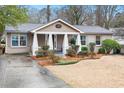 Cozy home with a welcoming front porch, neat landscaping, and a paved driveway at 2413 Drew Valley Rd, Brookhaven, GA 30319