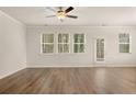 Bright living room with wood-look floors, large windows, and a ceiling fan at 1084 Georgian Point Dr, Lawrenceville, GA 30045