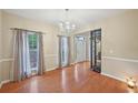 A dining room features hardwood floors, natural light, and a stylish chandelier at 12947 Dunand Blvd, Hampton, GA 30228