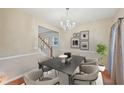 Cozy dining area featuring modern chandelier, table, and decor, adjacent to the stairs and living areas at 12947 Dunand Blvd, Hampton, GA 30228