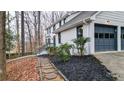 Side view of the house featuring painted brick, a two-car garage and a stone pathway leading to the front entrance at 2414 Cedar Wood Ct, Marietta, GA 30068