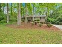 Inviting front exterior of a home with beautiful landscaping and mature trees at 8980 Country Club Dr, Douglasville, GA 30134