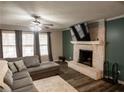 Cozy living room with a brick fireplace, modern flooring, and a comfortable sectional sofa at 8980 Country Club Dr, Douglasville, GA 30134