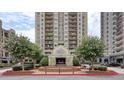 Beautiful exterior view of Park Towers, a luxury high-rise featuring a circular driveway and manicured landscaping at 795 Hammond Dr # 709, Atlanta, GA 30328