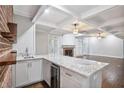 Wet bar featuring granite countertops, wine refrigerator, and stylish brick wall at 8900 River Trace Dr, Johns Creek, GA 30097