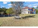 Serene backyard featuring a garden bench under a large tree, perfect for relaxation at 2316 Watson Fain Trl, Loganville, GA 30052