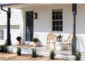 Inviting front porch with stylish seating, potted plants, and modern lighting fixture at 1370 Valley View Rd, Dunwoody, GA 30338