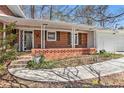 Inviting covered front porch on a charming brick home with a well-lit entryway and walkway at 2447 Caladium Ne Dr, Atlanta, GA 30345
